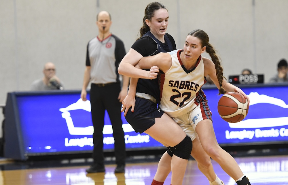 G.W. Graham's Holly-Rae Myrden (rear) guards Sa-Hali's Gwen Storry during Tsumura Basketball Invitational Super 16 opening-round action Dec. 10, 2025 at the Langley Event Centre’s Centre Court. (Photo by Howard Tsumura property of Varsity Letters 2025. All Rights Reserved)